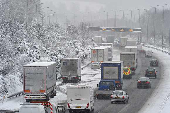 Trucks are parked on the hard shoulder of the M25 motorway near Reigate in south England