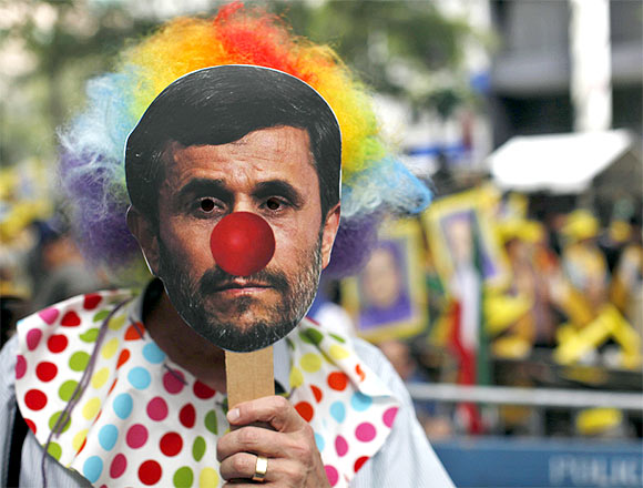 A protester wears a mask depicting Iran's President Mahmoud Ahmadinejad