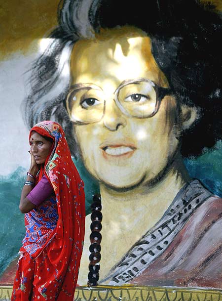 A woman passes a painting of Indira Gandhi in Kolkata