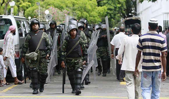 Army soldiers patrol a street in Male