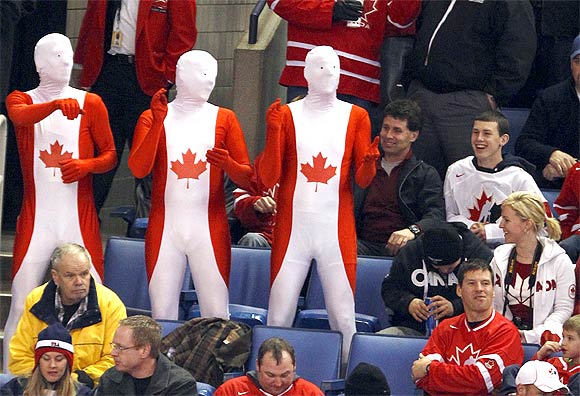Team Canada fans dance and cheer during a hockey game