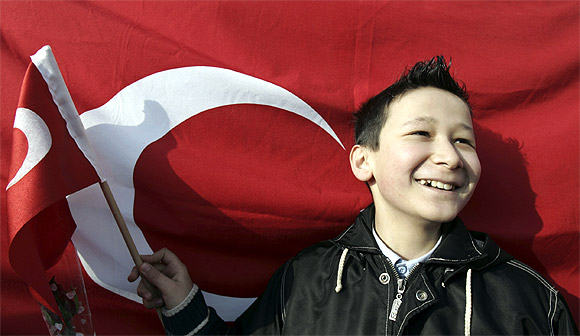 A child waves a Turkish flag during a ceremony to mark National Sovereignty and Child's Day