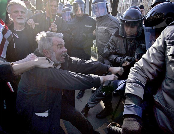 A Hungarian protestor fights with the riot police in front of the parliament in Budapest