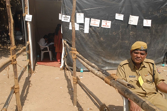 A lone policeman guards a nearly-empty polling booth