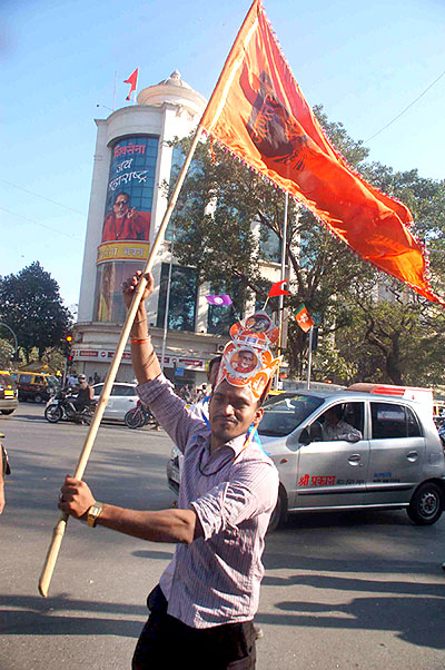 A Shiv Sena supporter celebrates the party's civic victory outside Sena Bhavan, the party's headquarters, in Mumbai