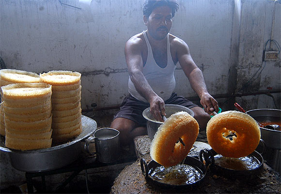 A worker prepares sweets at a shop in Lucknow