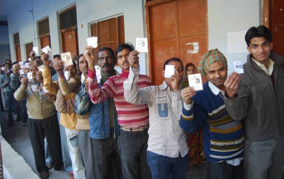 Voters display they voter ID cards outside a polling booth