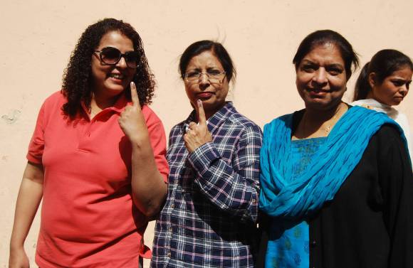 Voters show the indelible ink mark on their fingers after casting their vote