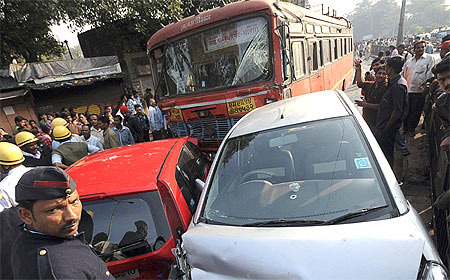 Onlookers and rescue workers gather around the bus and other vehicles after the Pune tragedy