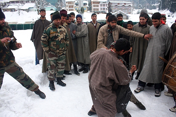 Youth wrestle on snow as Army jawans look on