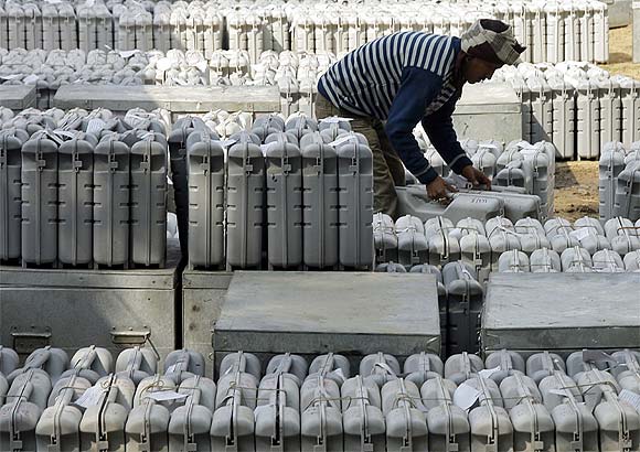 A polling official collects electronic voting machines from a distribution centre