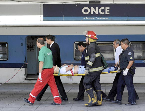 Rescue workers carry a wounded passenger from the commuter train