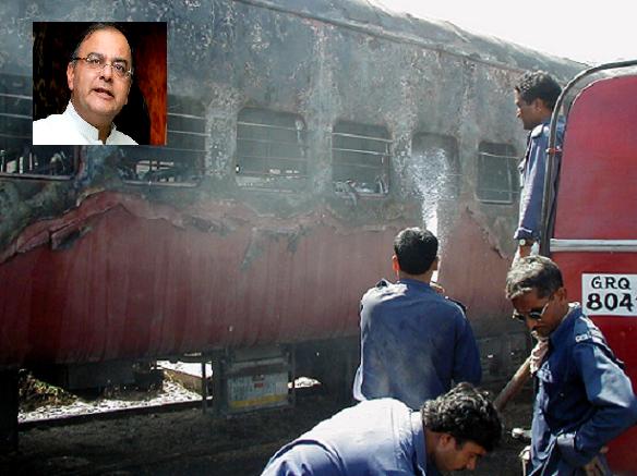Firemen try to put out a fire on the Sabarmati Express in Godhra, Gujarat February 27, 2002. Inset: Arun Jaitley