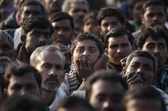 Supporters of Rahul Gandhi listen intently as he delivers a speech at an election campaign rally at Hardoi district