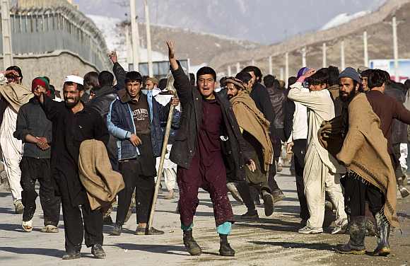 Afghan protesters gesture towards police in Kabul. Two protesters were shot dead in separate rallies in Kabul on Friday over the burnings of the Quran at a NATO base