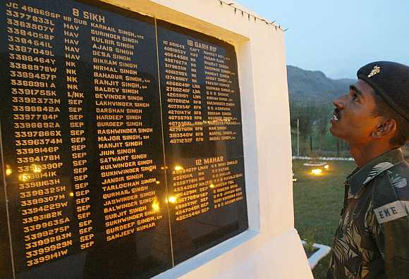 A soldier looks at the names of fallen colleagues at a war memorial during Vijay Diwas or Victory Day celebrations in Drass. The Indian army commemorates Vijay Diwas in memory of their more than 500 colleagues who were killed during the Kargil war with Pakistan