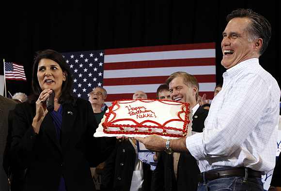 Mitt Romney presents a birthday cake to Nikki Haley during a campaign rally in North Charleston