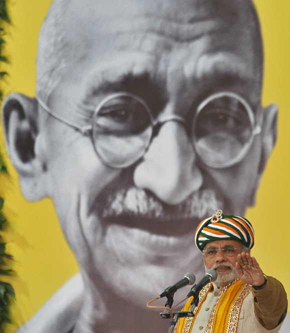 Gujarat's CM Narendra Modi addresses a gathering in front of a portrait of Mahatma Gandhi during his day-long fast at Godhra