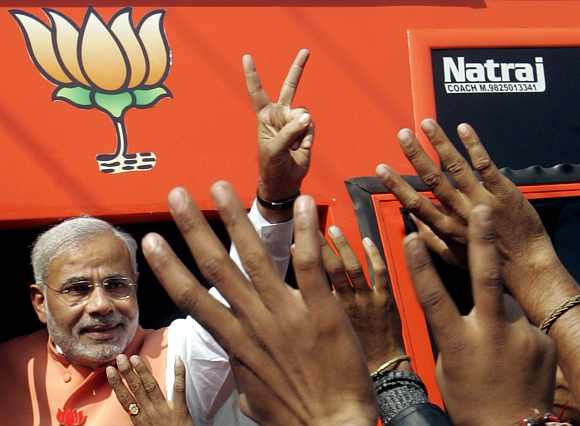 Gujarat CM Modi shows victory sign to his supporters at Godhra