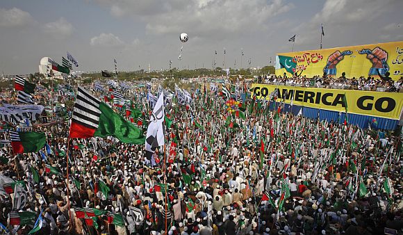 Hundreds of supporters of different religious and political parties hold their parties flags while taking part in an anti-American rally organised by the Difa-e-Pakistan Council in Karachi