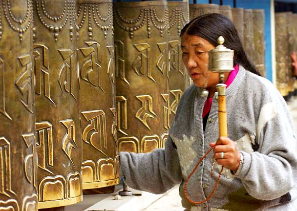 A Tibetan refugee moves prayer wheels at a monastery in Dharamsala