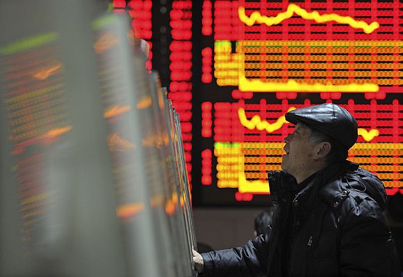 An investor checks stock information with a computer at a brokerage house in Anhui province of China