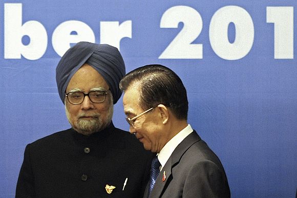 China's Premier Wen Jiabao walks past PM Singh ahead of a photo opportunity during 5th East Asia Summit in Hanoi, on October 30, 2010.