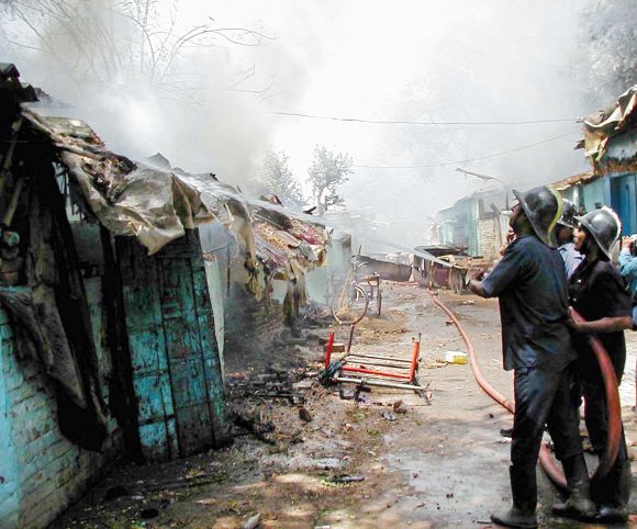 Firemen fight a blaze in a riot-hit neighbourhood of Ahmedabad, on May 11, 2002.