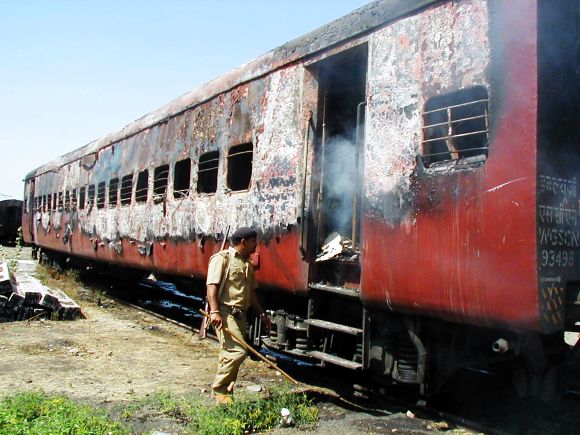 Policeman walks towards the entrance of a carriage of Sabarmati Express train in Godhra