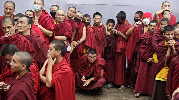 Buddhist monks wait to enter the complex to attend a teaching session being addressed by the Dalai Lama on the first day of the Kalachakra festival