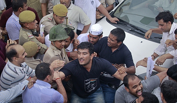 Police try to remove supporters of Hazare who were attempting to block the vehicle carrying Hazare after he was arrested by police in New Delhi on August 16, 2011