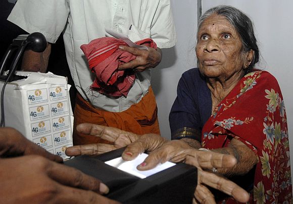 File picture of a woman undergoing the process of a fingerprint scanner during UID database system in a village in Andhra Pradesh