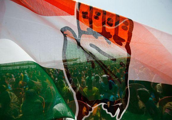 People attending election campaign rally are seen through Congress flag in West Bengal