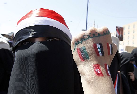 An anti-government protester displays paintings on her hand in Sanaa, Yemen