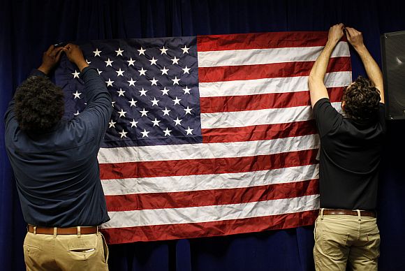Volunteers hang an American flag before a US Presidential candidate's campaign town hall meeting in Concord