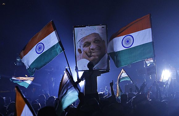 A supporter of Anna Hazare holds his portrait during his fast at Ramlila grounds in New Delhi in this file picture