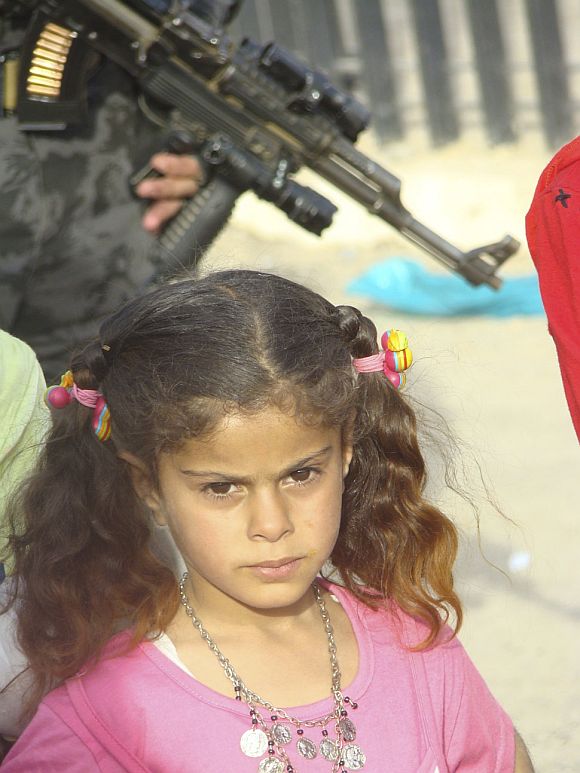 A girl stands near a policeman providing security in the city of Kut, 150 km (95 miles) southeast of Baghdad in this 2009 photo