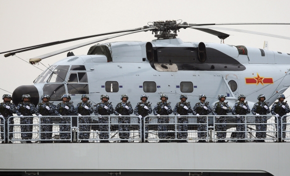 Chinese Marines stand at attention on a warship with a Changhe Z-8 helicopter