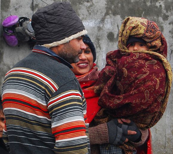 A tourist family wrapped in heavy winter wear is seen in Srinagar on Monday
