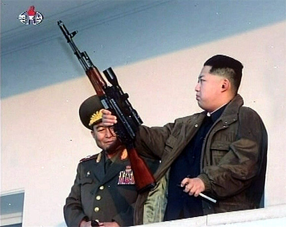 New leader of North Korea Kim Jong-un holds a weapon in this undated still image taken from video