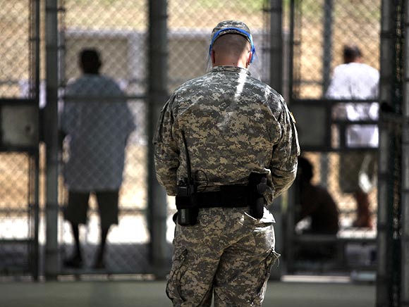 A guard watches over Guantanamo detainees inside the exercise yard at Camp 5 detention facility at Guantanamo Bay