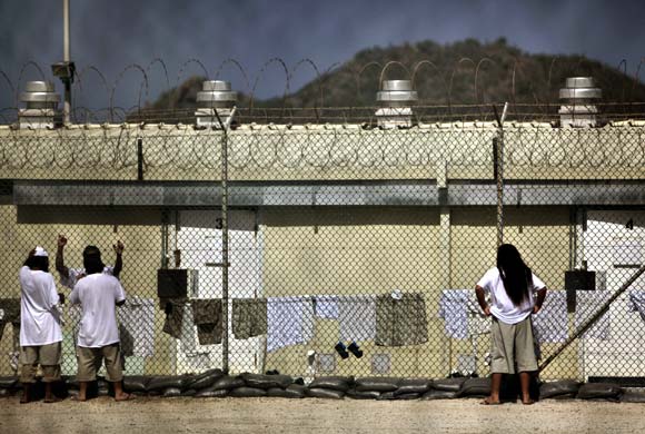 Detainees talk together inside the open-air yard at the Camp 4 detention facility at Guantanamo Bay