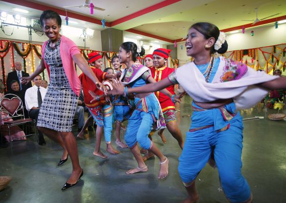 U.S. President Barack Obama and first lady Michelle Obama dance during their visit to the Holy Name High School in Mumbai
