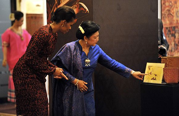 Michelle Obama tours an exhibition with Ani Yudhoyono, wife of Indonesia's President Susilo Yudhoyono, in Jakarta