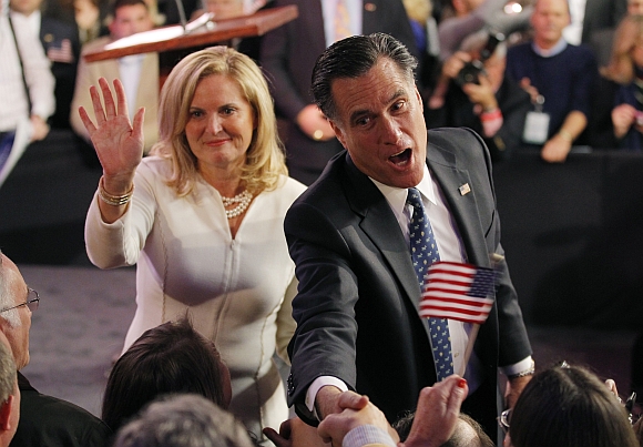 Romney shakes hands with supporters as his wife Ann waves after he spoke at his New Hampshire primary night rally