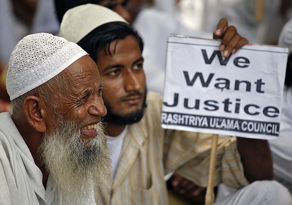 Members of Rashtriya Ulama Council hold a placard as they take part in a protest against what they call a fake encounter, in New Delhi