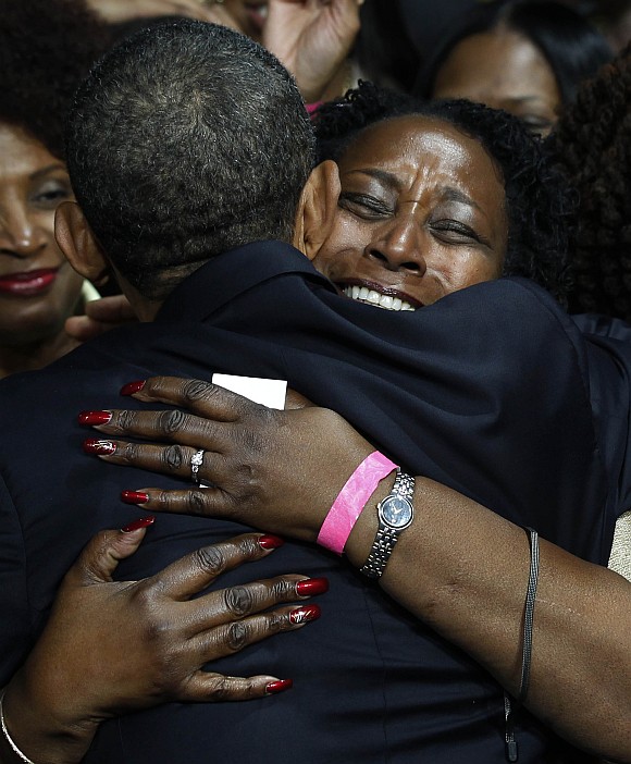 A supporter hugs U S President Barack Obama after his speech at a Chicago Forum event at the University of Illinois in Chicago