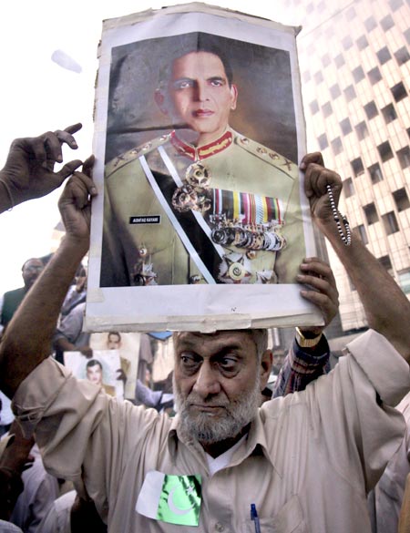 A man holds up a poster of Pakistan's army chief General Ashfaq Kayani