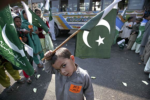 A school boy waves Pakistan's national flag