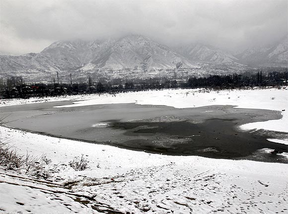 A view shows the semi-frozen layer of a water reservoir on a cold day on the outskirts of Srinagar